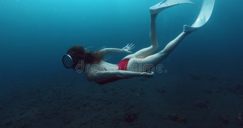 Deep ocean underwater and woman freediver swims close to the sea bottom. stock footage